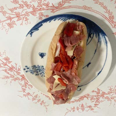 A hearty mix of Italian meats and cheeses finely chopped and layered with lettuce, tomato, oil, and vinegar on crusty bread.