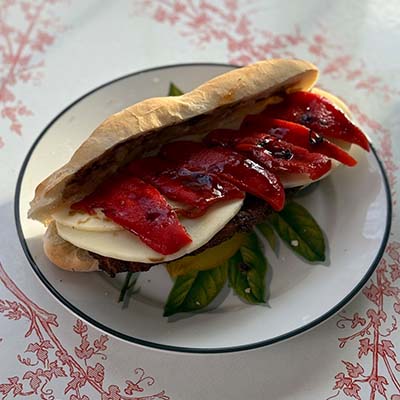 Breaded chicken cutlet stacked with roasted red peppers, fresh mozzarella, and a balsamic glaze on a toasted roll.