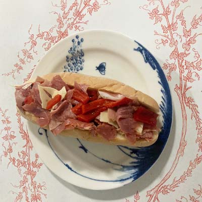 A hearty mix of Italian meats and cheeses finely chopped and layered with lettuce, tomato, oil, and vinegar on crusty bread.